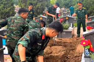 Các đơn vị thực hiện khai quật, lấy mẫu hài cốt liệt sĩ tại Nghĩa trang liệt sĩ Nhổn. (Ảnh: Mai Hoa)