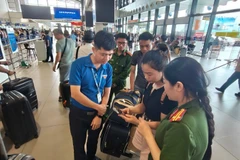 Hành khách được lực lượng chức năng hướng dẫn check in online dịch vụ hàng không trực tuyến trên ứng dụng VNeID.