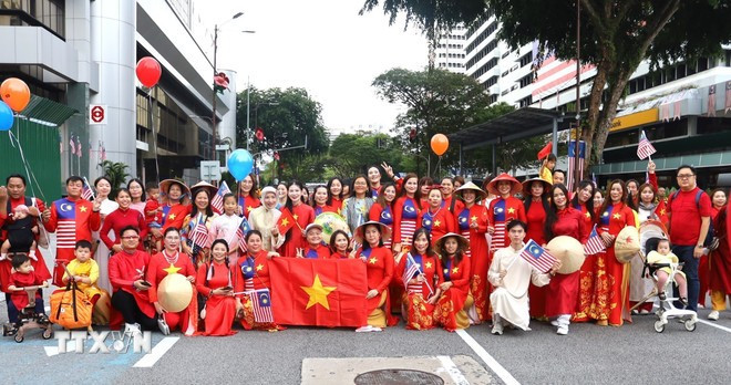 Cộng đồng người Việt tại Malaysia chụp ảnh lưu niệm cùng Thị trưởng Kuala Lumpur Maimunah Binti Mohd Sharif (hàng sau, giữa, khăn xanh) sau khi kết thúc diễu hành. (Ảnh: TTXVN) Cộng đồng người Việt tại Malaysia chụp ảnh lưu niệm cùng Thị trưởng Kuala Lumpur Maimunah Binti Mohd Sharif (hàng sau, giữa, khăn xanh) sau khi kết thúc diễu hành. (Ảnh: TTXVN)