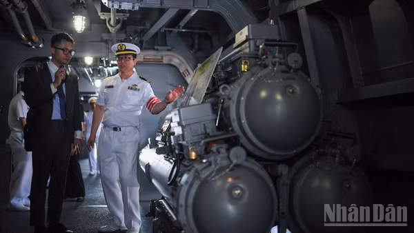 Sĩ quan tàu giới thiệu cụm bệ phóng ngư lôi chống ngầm trên tàu hộ vệ Asahi của lực lượng tự vệ trên biển Nhật Bản.