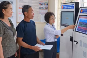Cán bộ phường Mường Thanh hướng dẫn người dân thực hiện thủ tục hành chính trên cây ki-ốt tại trụ sở Ủy ban nhân dân phường.