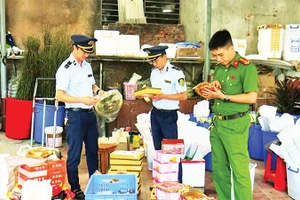 Lực lượng chức năng phát hiện, thu giữ bánh trung thu và một số thực phẩm nhập lậu tại hộ kinh doanh Lý Nguyễn Minh Châu. (Ảnh TRÍ DŨNG)