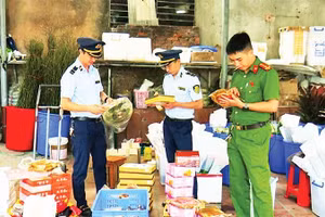 Lực lượng chức năng phát hiện, thu giữ bánh trung thu và một số thực phẩm nhập lậu tại hộ kinh doanh Lý Nguyễn Minh Châu. (Ảnh TRÍ DŨNG)