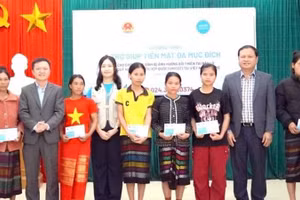 Các đại biểu trao trợ giúp tiền mặt tặng hộ gia đình bị ảnh hưởng thiên tai ở xã Kim Ngân, tỉnh Quảng Trị. (Ảnh NH)