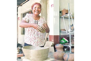 Nghệ nhân Neáng Sana bên những sản phẩm gốm thủ công.