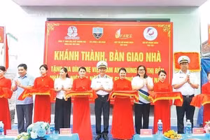 Các đại biểu và gia đình Mẹ Việt Nam Anh hùng Bùi Thị Bẻn cắt băng khánh thành nhà (Ảnh CTV)