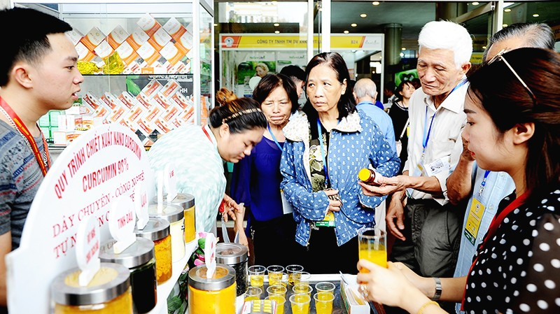 Doanh nghiệp giới thiệu loại nước uống được chiết xuất từ nghệ. Ảnh: NGUYỆT ANH