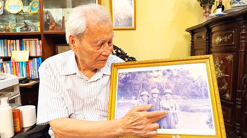 Ông La Văn Sàng bên tấm ảnh chụp cùng các chuyên gia Liên Xô.