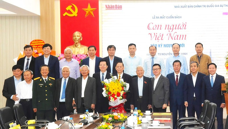 PGS, TS Nguyễn Hồng Vinh (cầm hoa) cùng các đại biểu, đồng nghiệp chụp ảnh lưu niệm trong lễ ra mắt sách.