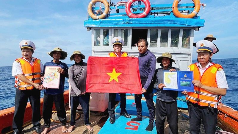 Tổ Bầu cử trao cờ Tổ quốc và quà cho các ngư dân tàu QNg 96435 TS, sau khi các ngư dân tàu hoàn thành bầu cử.