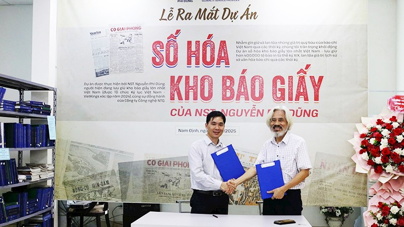 Nhà sưu tầm Nguyễn Phi Dũng (bên phải) và đại diện Công ty cổ phần NTQ Solution tại Lễ ra mắt Dự án Số hóa kho báo giấy.