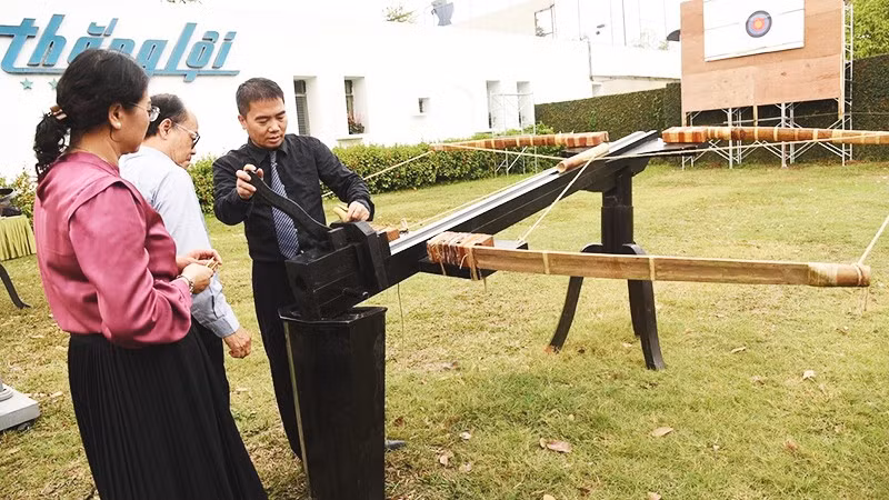 Kỹ sư Vũ Đình Thanh (áo đen) giới thiệu cấu tạo nỏ thần Cổ Loa phục dựng.