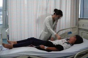 Nhân viên Bệnh viện đa khoa Vũng Tàu theo dõi một bệnh nhân ngộ độc nghi do ăn bánh mì ở đường Đồ Chiểu, phường Vũng Tàu. 