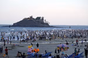 Du khách tắm biển Bãi Sau chiều 30/4, phía xa là Hòn Bà.