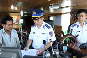 Cán bộ của Bộ Tư lệnh Vùng Cảnh sát biển 3 kiểm tra hành chính một tàu trên biển. 