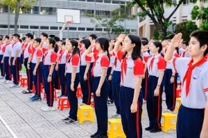 Học sinh Trường trung học cơ sở Nguyễn An Ninh, phường Tam Thắng, Thành phố Hồ Chí Minh chào cờ. 