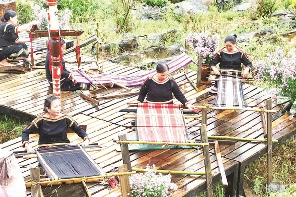 Người phụ nữ Ê Đê bên khung dệt vải thổ cẩm.