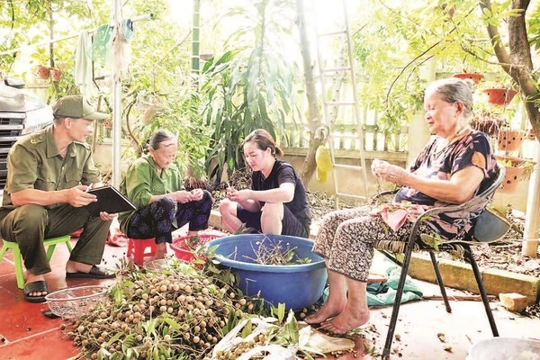 Anh Phạm Văn Cường (ngoài cùng bên trái) thường xuyên đến các hộ dân để nắm bắt tình hình an ninh trật tự cơ sở.