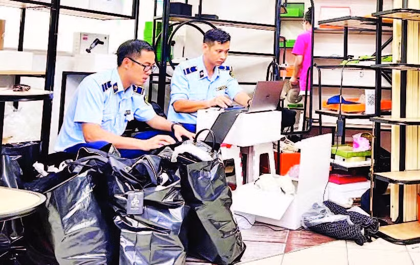 Lực lượng quản lý thị trường kiểm tra hàng hóa có dấu hiệu giả mạo tại điểm mua sắm Saigon Square (Quận 1) cuối tháng 5 vừa qua. (Ảnh CTV)