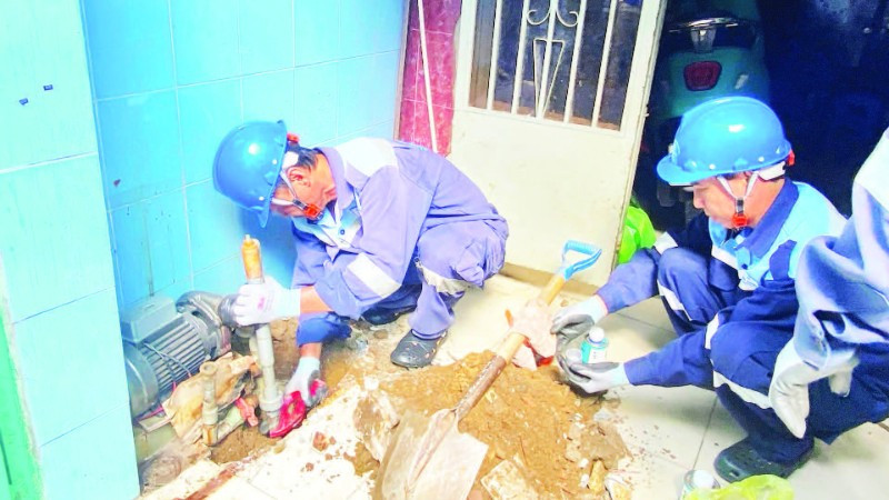 Công nhân Công ty cổ phần cấp nước Gia Định trám, lấp một giếng khoan tại phường Phú Nhuận nhằm hạn chế những tác động tiêu cực do hiện tượng mạch nước ngầm sụt giảm. (Ảnh QUÝ HIỀN)