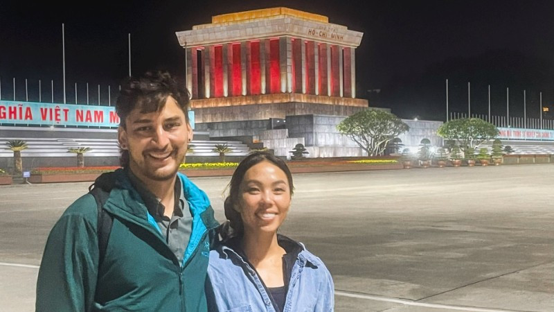 Anh Jack Warren và chị Annie Tao, du khách đến từ Mỹ, chụp ảnh lưu niệm bên Lăng Bác, tháng 1/2026. (Ảnh NVCC)
