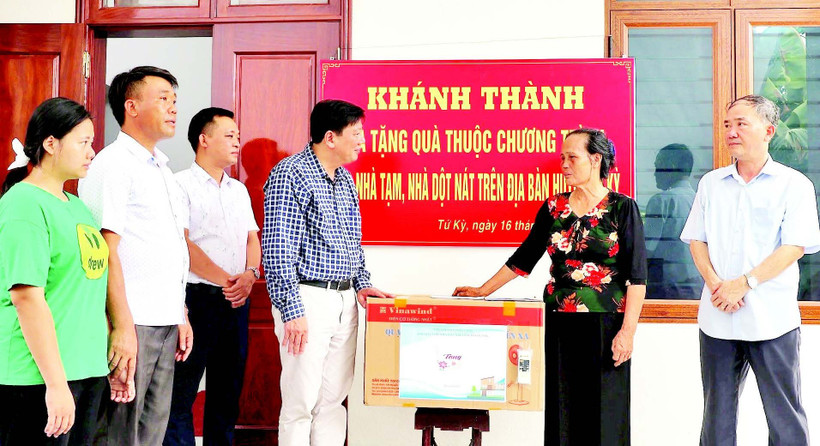 Đại diện chính quyền địa phương tặng quà gia đình bà Phạm Thị Thoa (ở xã Lạc Phượng) được hỗ trợ xây nhà mới.