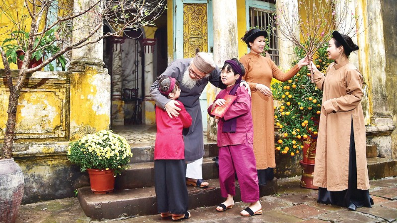 Nụ cười sum vầy của gia đình miền bắc với cành đào xuân là biểu tượng thiêng liêng của sự gắn kết và ấm áp trong ngày Tết cổ truyền.