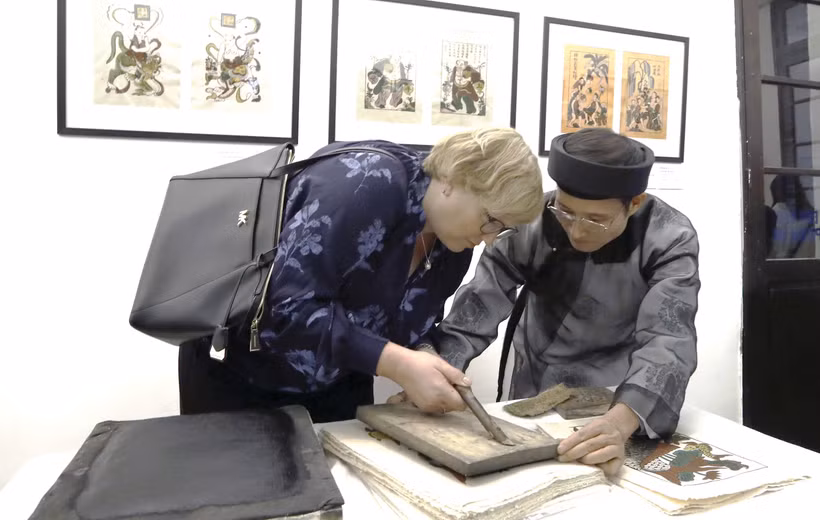 Nghệ nhân Nguyễn Hữu Quả giới thiệu kỹ thuật in tranh Đông Hồ tới du khách quốc tế, tại Bảo tàng Mỹ thuật Việt Nam.