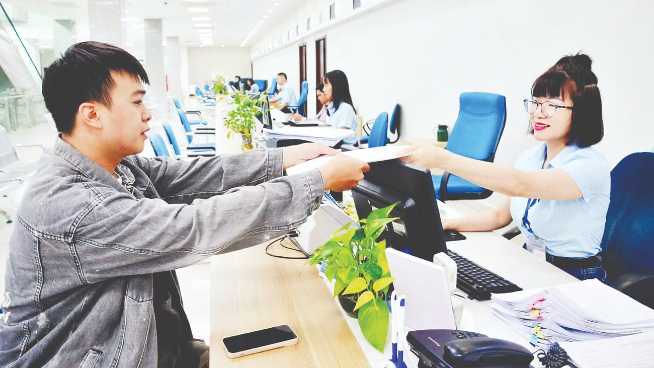 Cán bộ Trung tâm Phục vụ hành chính công tỉnh Quảng Ninh tiếp nhận, xử lý hồ sơ của công dân. (Ảnh THANH HOA)