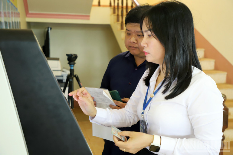 Cán bộ xã Kiến Đức hướng dẫn người dân bấm số thứ tự thực hiện thủ tục hành chính. ndo_br_kd-3.jpg