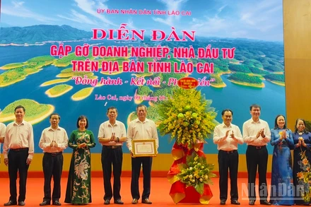 Lãnh đạo tỉnh Lào Cai tặng hoa và Bằng khen đối với Hiệp hội Doanh nghiệp tỉnh. (Ảnh: THANH SƠN)