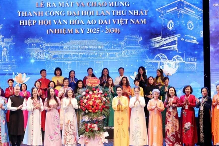 Chủ tịch Hiệp hội Văn hóa Áo dài Đặng Thị Bích Liên cùng thành viên Hiệp hội nhận hoa chúc mừng từ các đại biểu. (Ảnh: Ban tổ chức cung cấp)