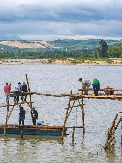 Người dân xây dựng lại cầu gỗ Ông Cọp sau khi công trình bị lũ cuốn đi vào tháng 11 vừa qua.