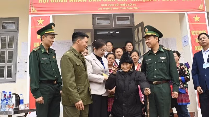 Đại tá Lê Đức Nghĩa cùng cán bộ, nhân dân xã Mường Nhé trò chuyện, động viên cử tri cao tuổi nhất tỉnh Điện Biên là cụ bà Trá Thị Dềnh ở bản Nậm Là 2, xã Mường Nhé.