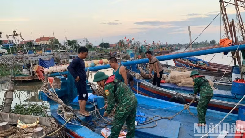 Cán bộ, chiến sĩ Đồn Biên phòng Đoàn Xá hỗ trợ ngư dân chằng buộc phương tiện phòng, chống bão Ragasa.