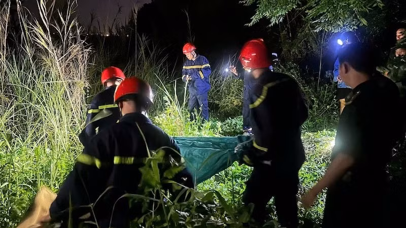 Lực lượng chức năng tiếp cận hiện trường, đưa thi thể nạn nhân ra khỏi khu vực bị nạn. (Ảnh: Công an cung cấp)