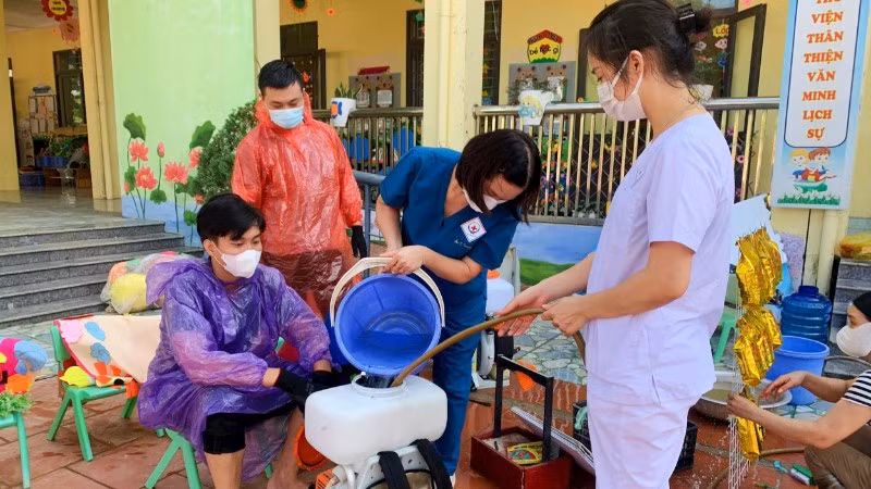 Cán bộ y tế phun hóa chất tiêu độc, khử trùng ở những nơi bị ngập lụt.