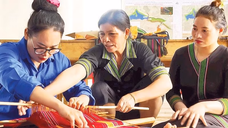 Nghệ nhân H'Yon (giữa) tỉ mỉ truyền dạy cho các học viên về cách tạo hoa văn trên nền thổ cẩm truyền thống của người M'nông bản địa.