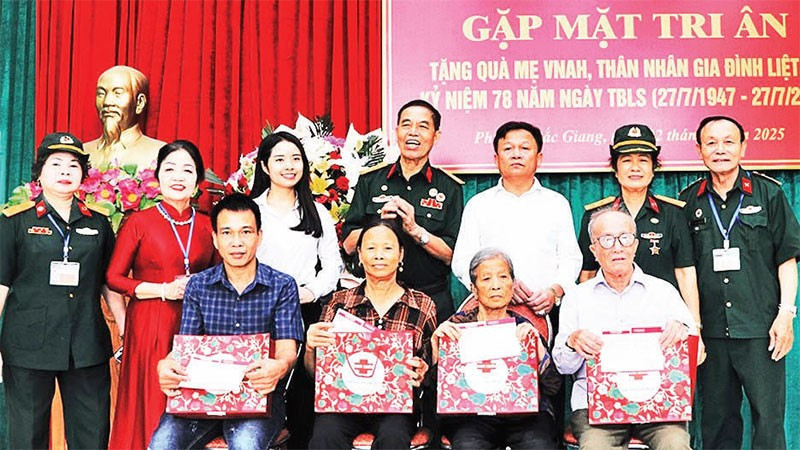 Ban Chấp hành Hội trao quà, sổ tiết kiệm tặng các thân nhân liệt sĩ. (Ảnh TRUNG ANH)