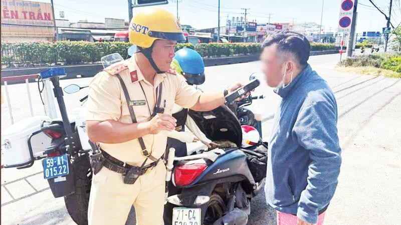 Cảnh sát giao thông kiểm tra nồng độ cồn của người điều khiển phương tiện tham gia giao thông.