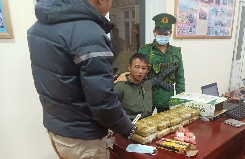 Đối tượng Thào A Pháng (người giữa) cùng tang vật khi bị Bộ đội Biên phòng tỉnh Điện Biên bắt giữ. 