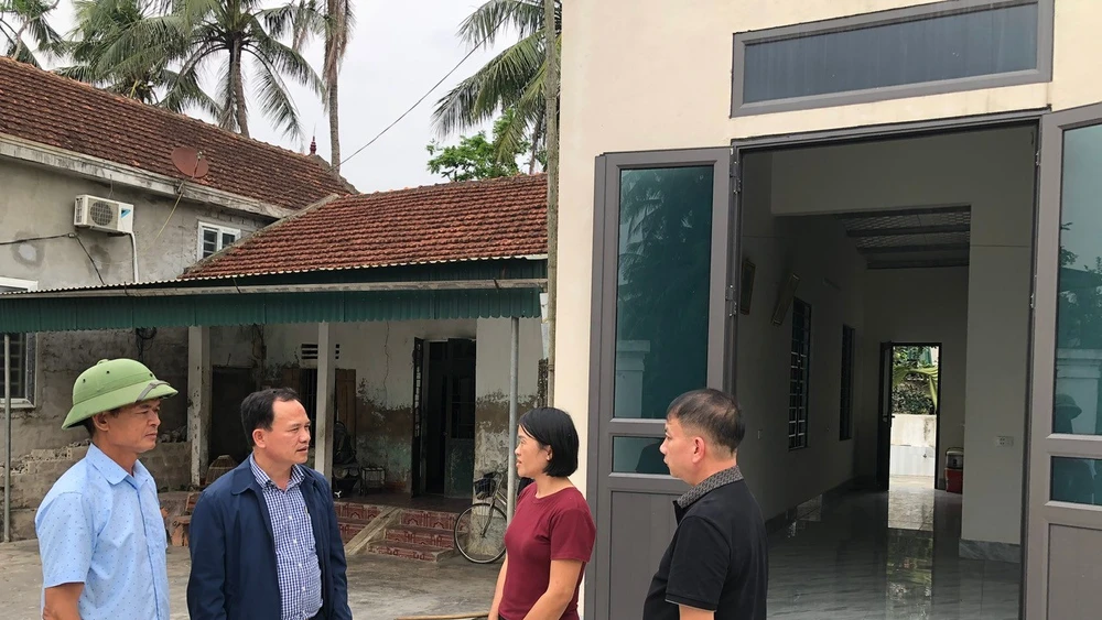 Cán bộ xã Đức Châu (Nghệ An) trao đổi với hộ nghèo được hỗ trợ xây nhà