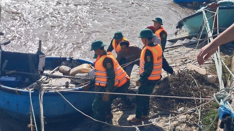 Bộ đội biên phòng hỗ trợ ngư dân kéo tàu lên.