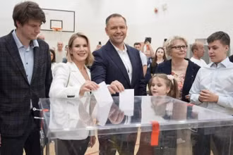 Ông Karol Nawrocki (giữa) bỏ phiếu bầu Tổng thống vòng 2 tại điểm bầu cử ở Warszawa, Ba Lan, ngày 1/6/2025. (Ảnh: Xinhua)