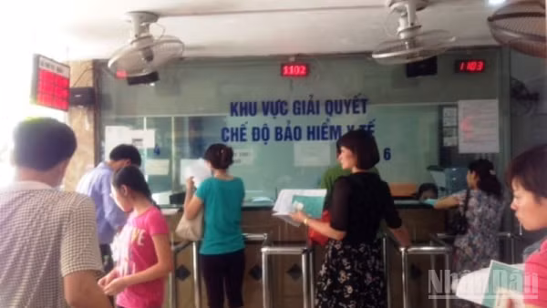 Người dân làm thủ tục đăng ký khám bệnh, chữa bệnh bảo hiểm y tế tại Bệnh viện. (Ảnh: ĐỖ THOA)