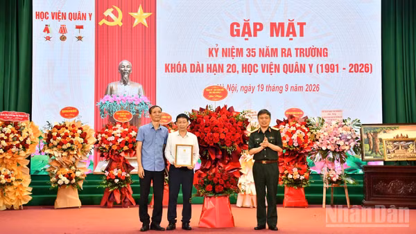 Thiếu tướng, Phó Giáo sư, Tiến sĩ Trần Ngọc Tuấn, Phó Giám đốc Học viện Quân y, thay mặt Đảng ủy, Ban Giám đốc Học viện Quân y tặng hoa chúc mừng Khóa 20. (Ảnh: TUẤN DŨNG)