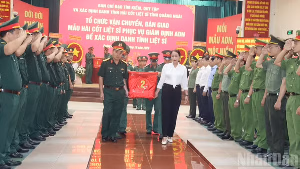 Các đại biểu thành kính, tiễn đưa mẫu sinh phẩm hài cốt các liệt sĩ bàn giao cho Viện Pháp y Quân đội phục vụ giám định ADN. (Ảnh: HIỂN CỪ)
