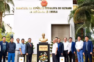 Đại sứ Dương Chính Chức cùng các cựu chiến binh chụp ảnh kỷ niệm bên Tượng đài Bác Hồ trong khuôn viên Đại sứ quán. (Ảnh: Đại sứ quán Việt Nam tại Angola cung cấp)