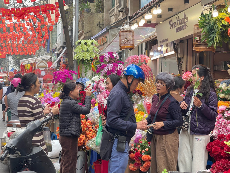 Người dân rộn ràng mua sắm hoa Tết trên khu vực phố cổ. (Ảnh: Trang Nhung)