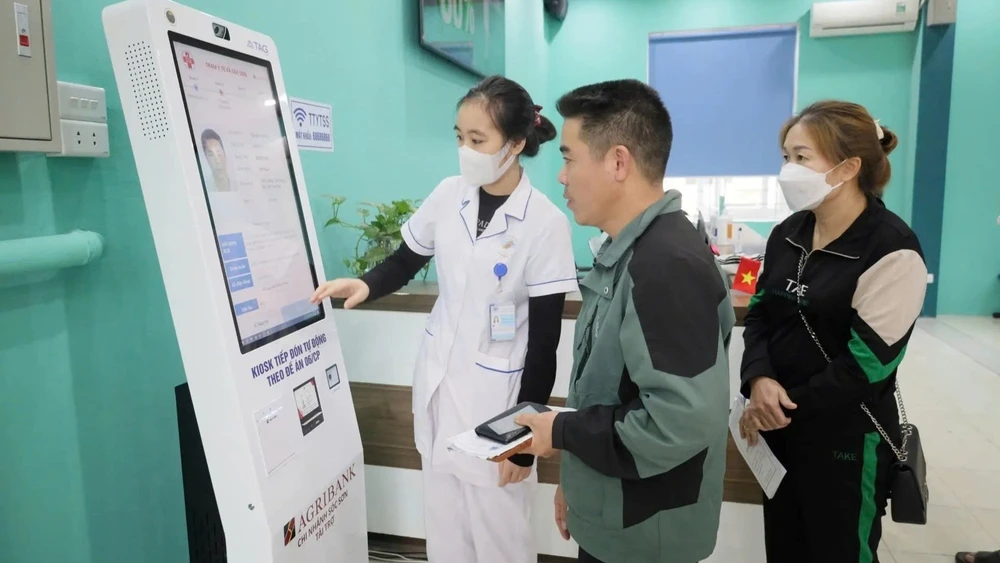 Ki-ốt tiếp nhận khám, chữa bệnh tự động phục vụ người dân khi đến đăng ký khám tại Trạm Y tế xã Sóc Sơn. (Ảnh THẢO TRẦN)